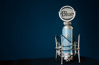 A sleek microphone with blue sound waves radiating against a clean, modern background.
