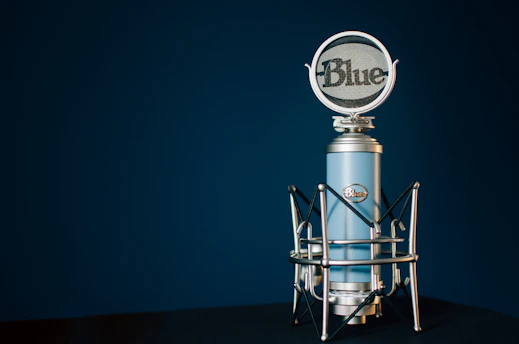 A close-up of a vintage microphone bathed in soft blue light, symbolizing the voice of Building Hendricks Blue.