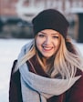 smiling woman wearing brown scarf and maroon coat on snow field