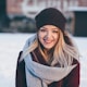 smiling woman wearing brown scarf and maroon coat on snow field