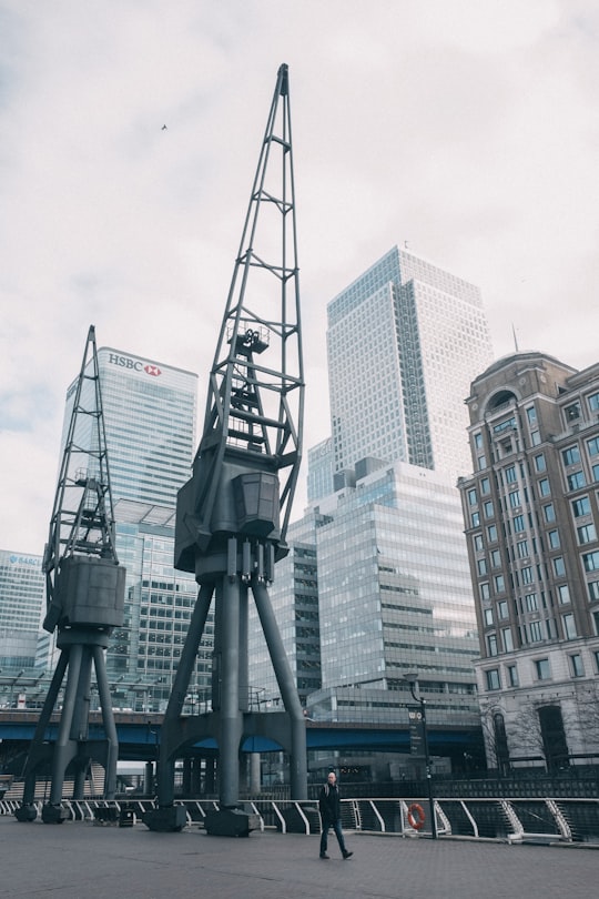 man walking near machines near buildings in Browns West India Quay United Kingdom