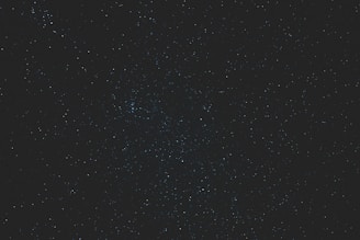 High resolution dynamic constellation image with scattered twinkling stars on a deep blue background.