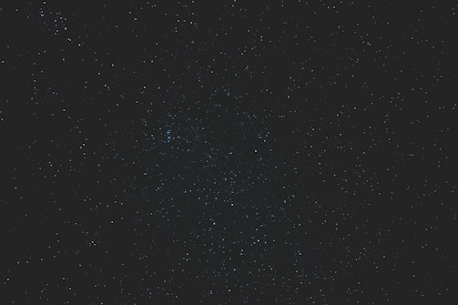 High resolution dynamic constellation image with scattered twinkling stars on a deep blue background.