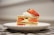 A layered dessert composed of crispy pastry, fresh strawberries, and cream is elegantly presented on a white plate resting on a checkered tablecloth.