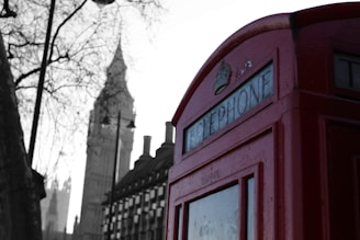 Historic red telephone booths and Big Ben in London, UK