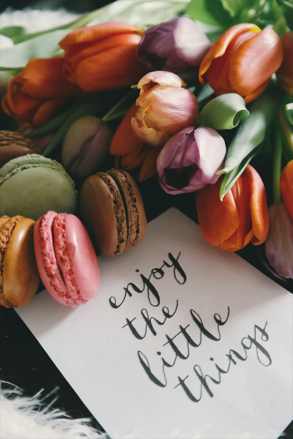 A piece of paper next to colorful snacks that reads "Enjoy the little things."