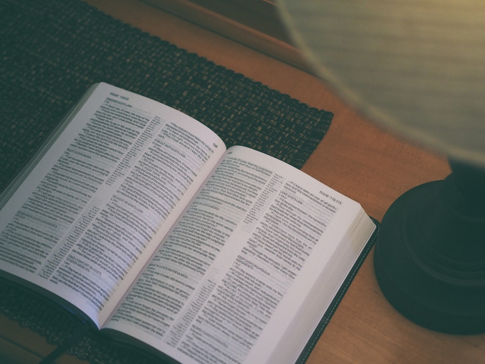 white book beside black table lamp