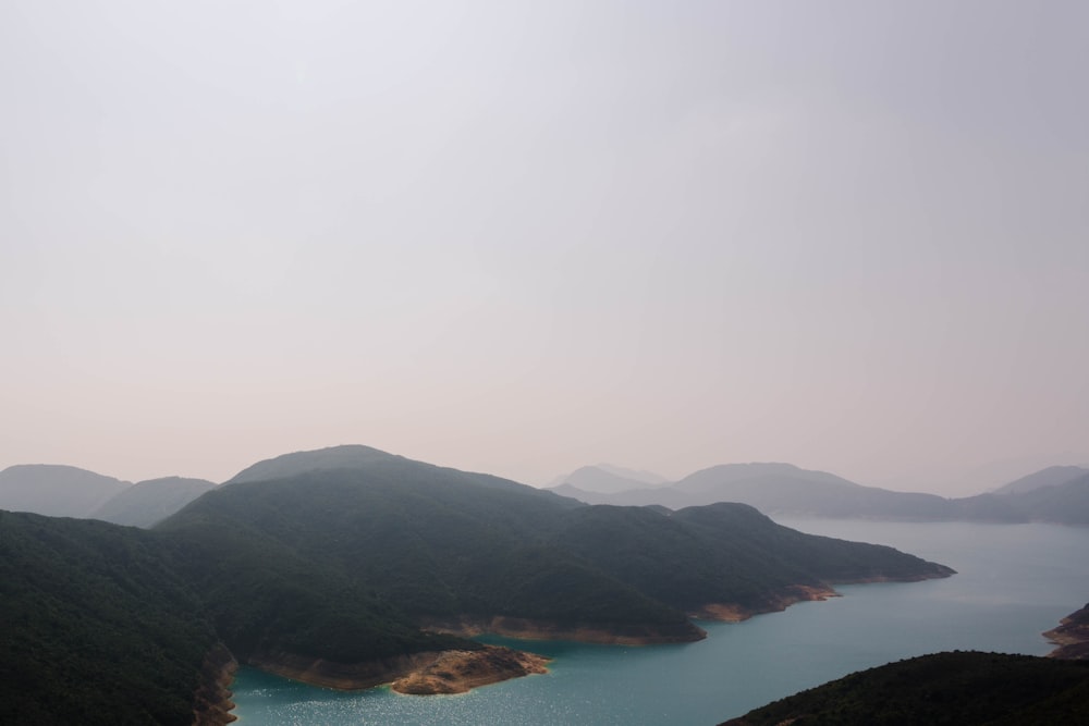 lake beside mountains during daytime