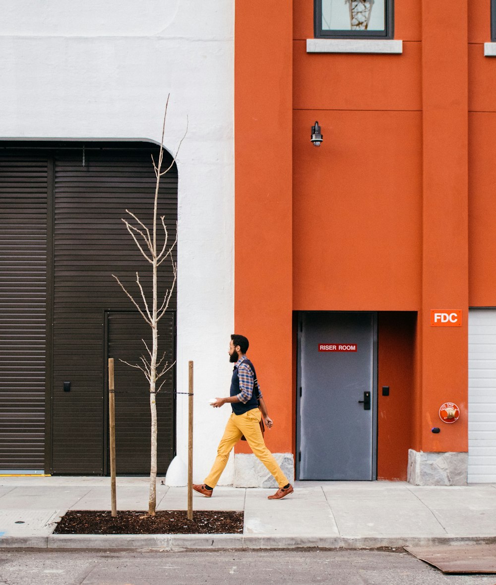 man walking beside building