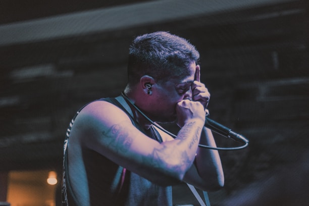 A close-up of a singer rehearsing with a microphone, showcasing determination.