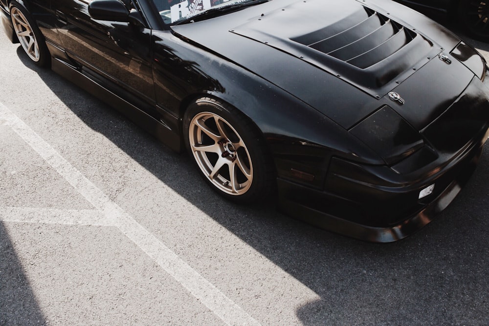 photo of black coupe parked on concrete pavement