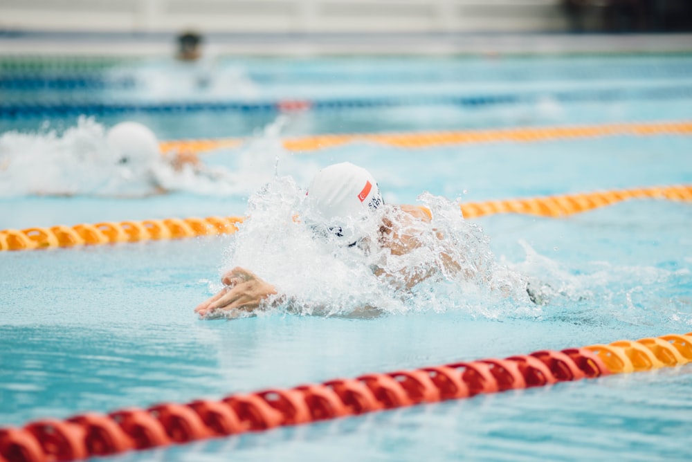 Foto Un hombre nadando en una piscina con un gorro de natación – Imagen  Sombrero gratis en Unsplash