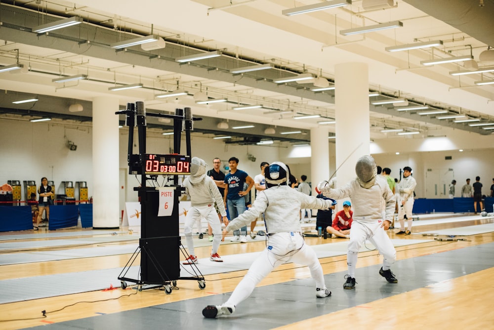 two person wearing white suit doing fencing