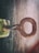 A close-up of a locksmith's hands working on a key with various keys and tools in the background.