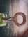 A close-up of a locksmith's hands working on a key with various keys and tools in the background.
