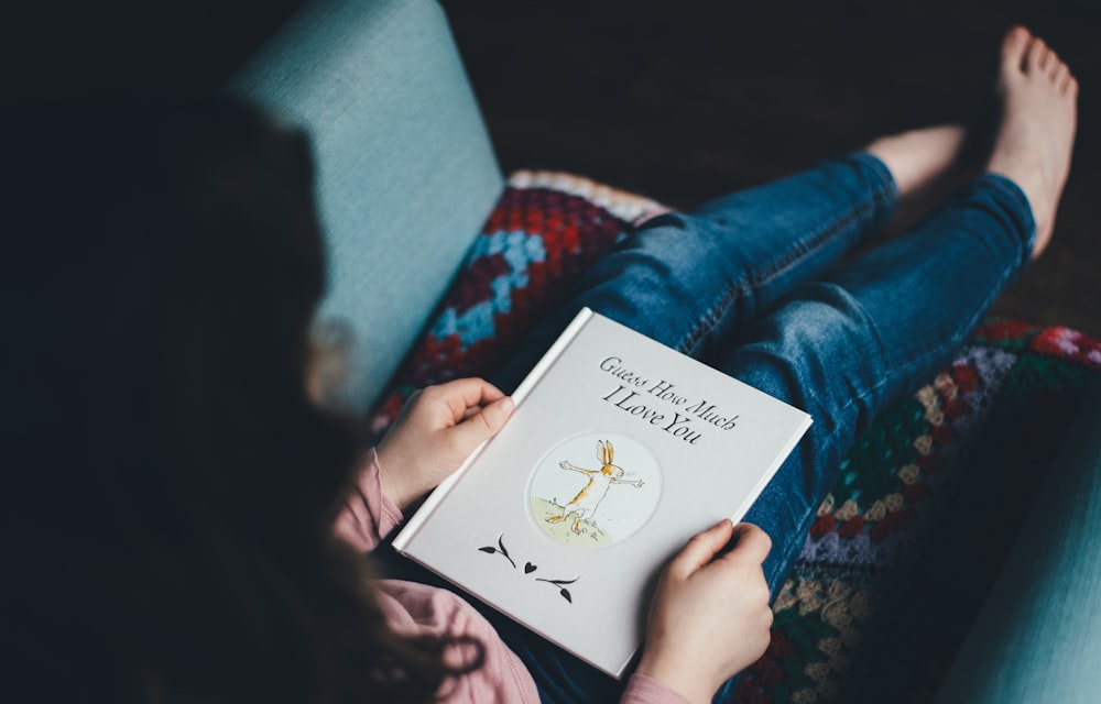 person sitting on chair reading book