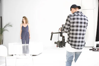 Behind-the-scenes shot of Faris directing a photoshoot with elegant beige and ivory tones.