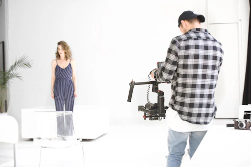 Behind-the-scenes shot of Faris directing a photoshoot with elegant beige and ivory tones.