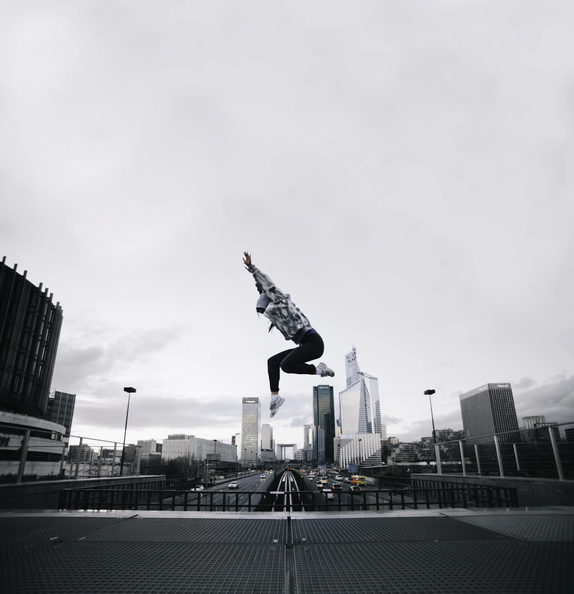 Jerry T. Adams performing a high-flying stunt against a dramatic cityscape backdrop at dusk.