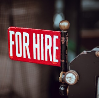 shallow focus photography of red and white for hire signage