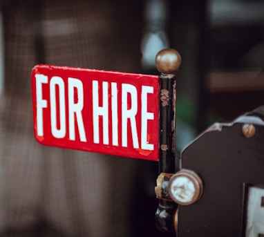 shallow focus photography of red and white for hire signage