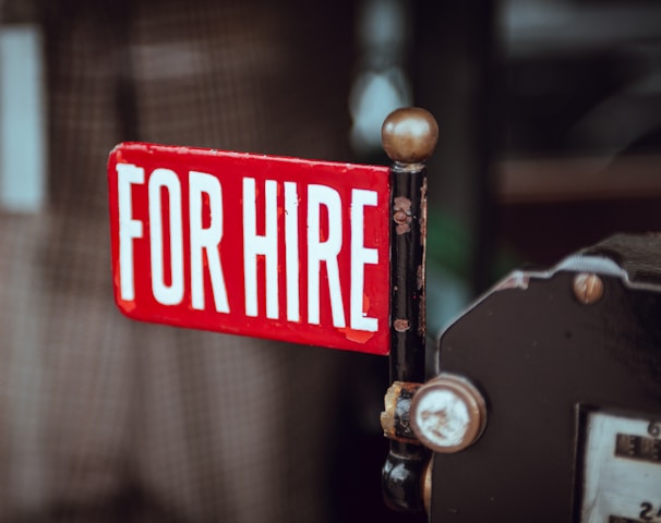 shallow focus photography of red and white for hire signage