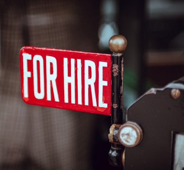 shallow focus photography of red and white for hire signage