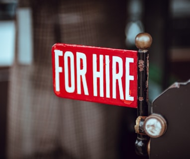 shallow focus photography of red and white for hire signage