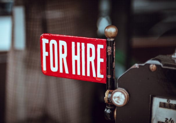 shallow focus photography of red and white for hire signage