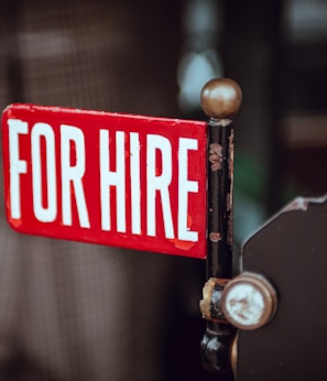 shallow focus photography of red and white for hire signage