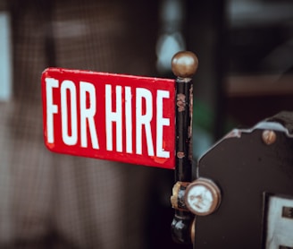 shallow focus photography of red and white for hire signage