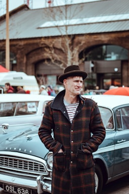photography poses for men,how to photograph street portrait; man wearing plaid button-up coat in front of classic car