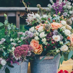 assorted flowers on gray metal bucket