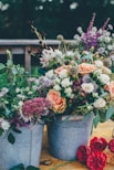 assorted flowers on gray metal bucket