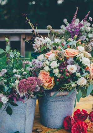 assorted flowers on gray metal bucket