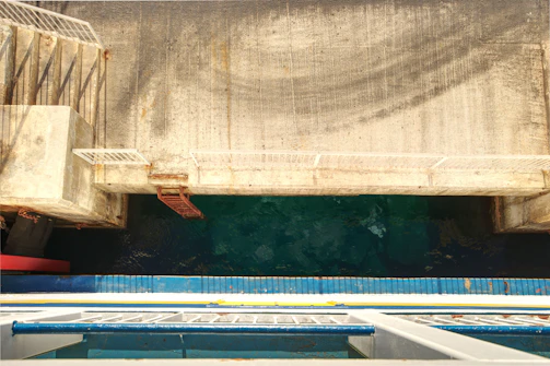 Close-up of sturdy marine FRP grating installed on a dock with water and boats in the background.