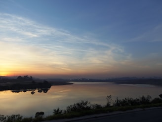 A serene sunrise over a calm lake reflecting soft colors.