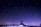 Under a vast, starry sky, an observatory stands silhouetted against a twilight backdrop. The scene captures a serene, night-time moment with a single person standing by the structure. The rich gradient of blue to purple across the sky adds depth and tranquility.