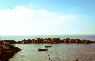A serene coastal scene at dusk highlighting a small maritime volunteer team preparing medical supplies for a transborder mission.