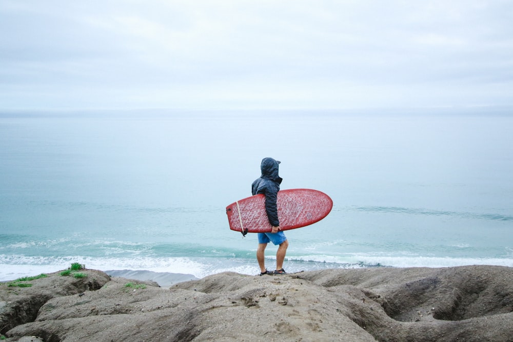 persona che tiene la tavola da surf