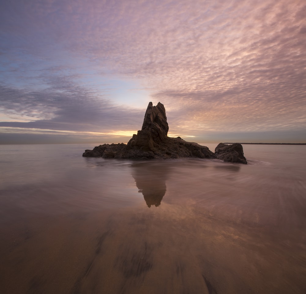 rock formation surrounded by water