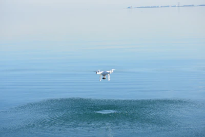 Close-up of a drone flying smoothly over a peaceful lake with mountains in the background.