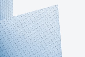 A modern architectural structure with geometric patterns of glass panels. The panels form a grid-like design on the facade of the building, featuring sleek lines and an angled perspective.