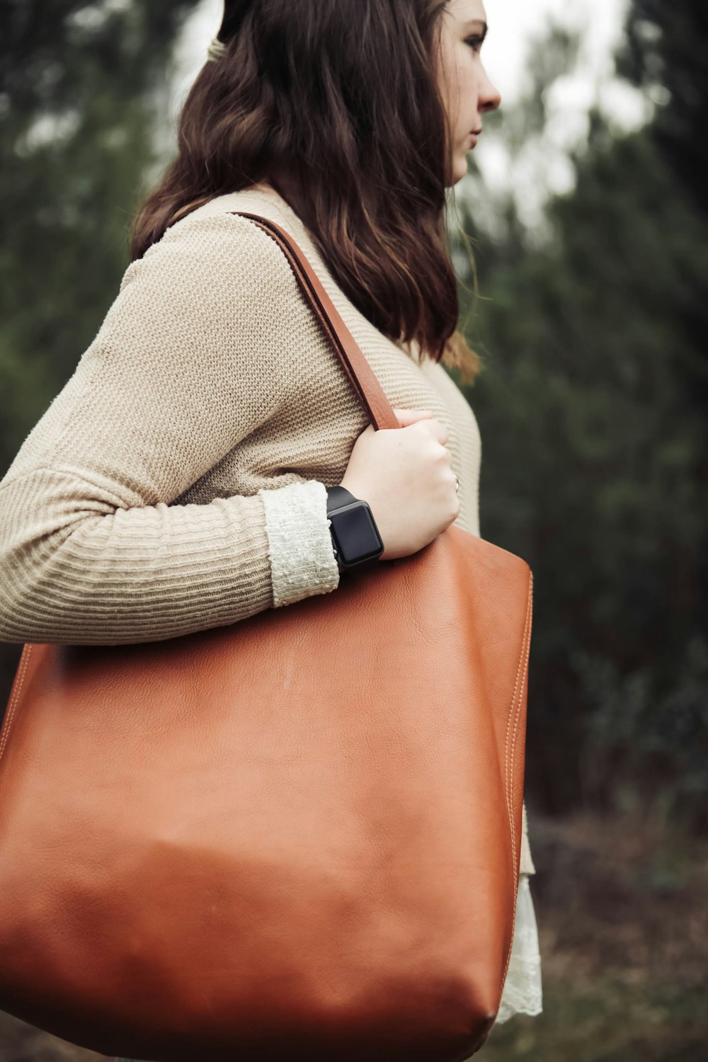 Eine Frau trägt eine braune Ledertasche