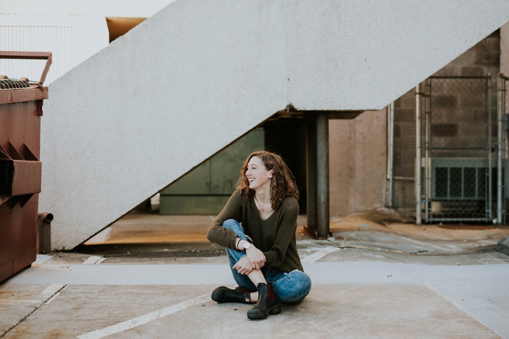 woman sitting near concrete staircase