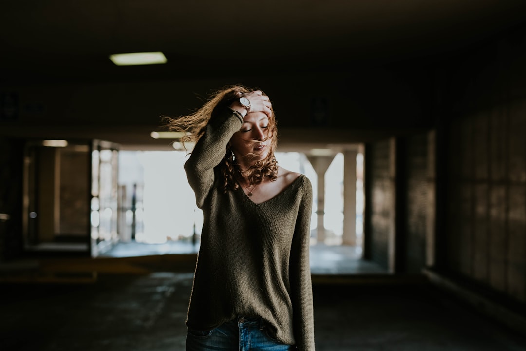 woman walking oh street while holding forehead,