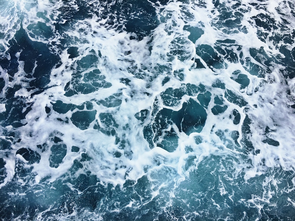 fotografia aérea de espuma do mar durante o dia
