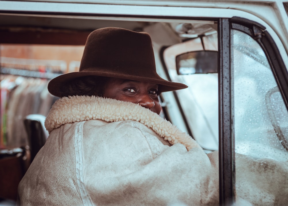 woman sitting in beige vehicle