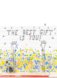 woman walking beside wall with the best gift is you graffiti