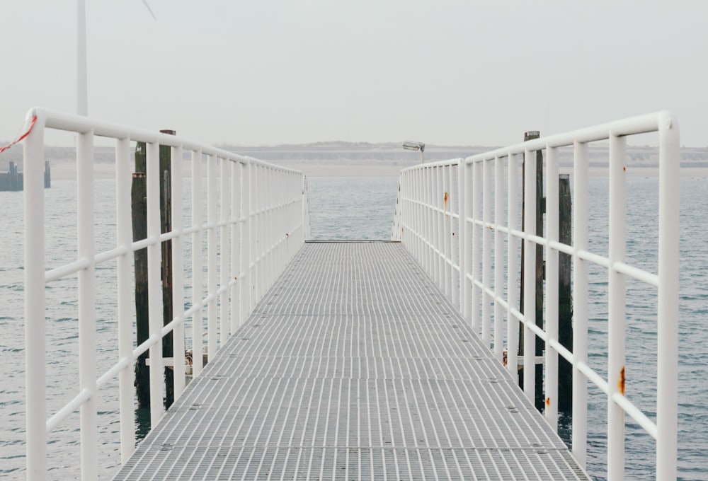 a pier with a wind turbine in the background